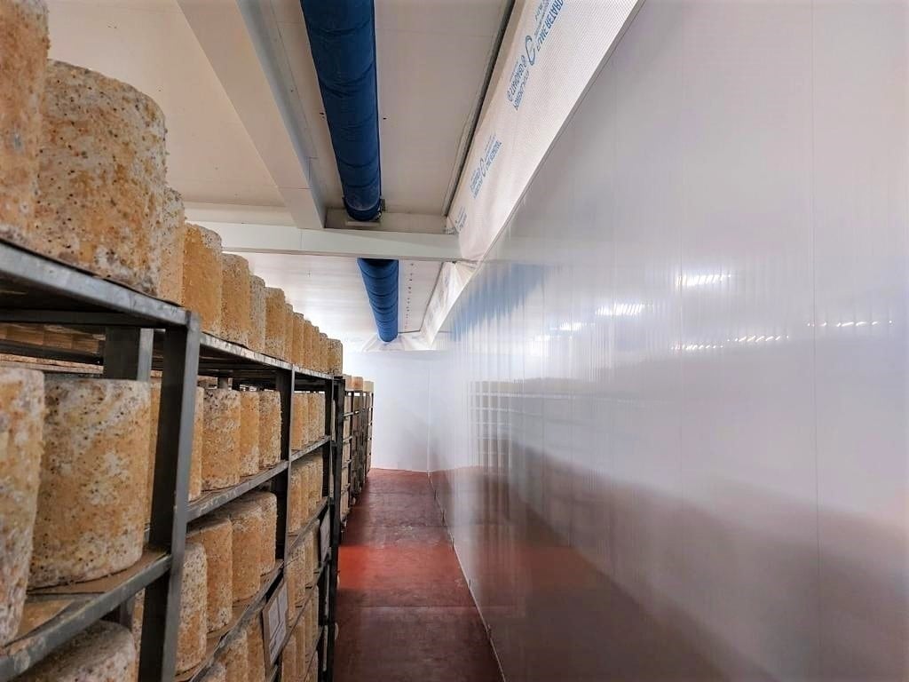 Racks of cheese stored near foodsafe partition